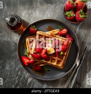 gaufres avec fraises, sirop et beurre Banque D'Images