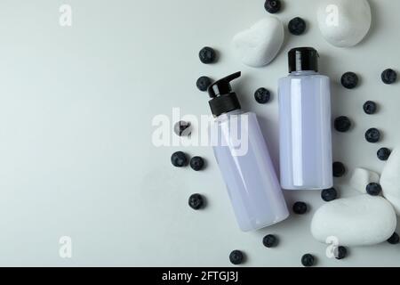 Gels douche, bleuets et pierres sur fond blanc Banque D'Images