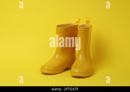 Bottes en caoutchouc pour le jardinage sur fond jaune Banque D'Images