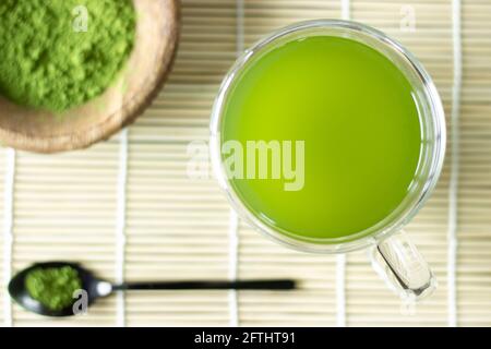 Boisson et poudre de matcha sur un tapis de bambou; thé vert japonais; service; matcha sur une cuillère; tasse de thé vert de matcha Banque D'Images