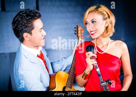 Chanteur et guitariste professionnel asiatique l'enregistrement de nouvelles chanson ou album CD en studio Banque D'Images