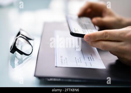 Prise d'une photo du document de vérification de la paie de dépôt à distance Banque D'Images