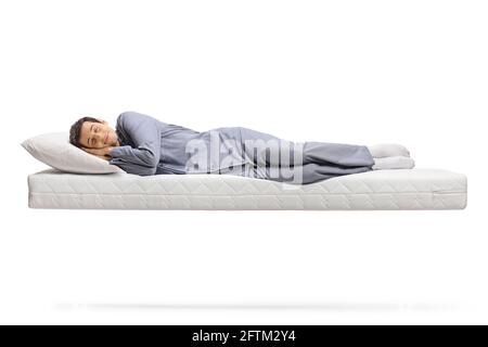 Photo d'un homme en pyjama qui dormait paisiblement sur un matelas flottant isolé sur fond blanc Banque D'Images