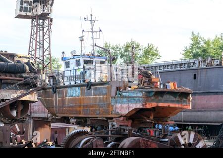 Petit navire à terre sur la cour de réparation de navire. Heure d'été. Banque D'Images