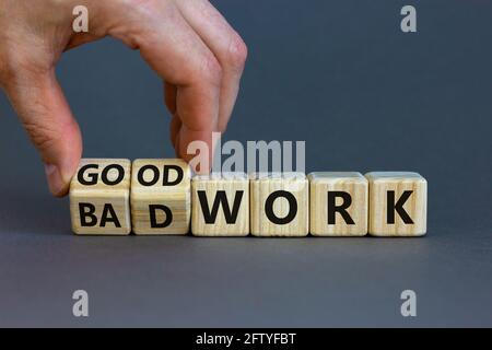Symbole de bon ou mauvais travail. Homme d'affaires transforme des cubes en bois et change les mots « mauvais travail » en « bon travail ». Magnifique arrière-plan gris, espace de copie. Affaires a Banque D'Images