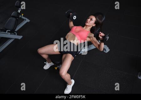 Vue de dessus d'une athlète féminine faisant la presse de banc avec poids Banque D'Images