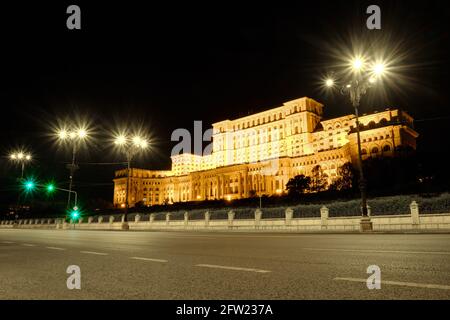 Palais du Parlement à Bucarest, en Roumanie, la nuit, avec des feux de rue sur une rue vide. Banque D'Images