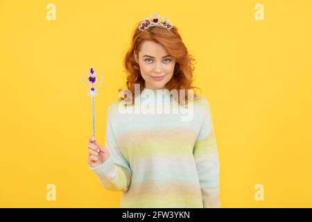 femme souriante à tête rouge dans la couronne de reine avec baguette magique, wish Banque D'Images