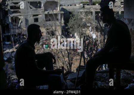 21 mai 2021, ville de Gaza, bande de Gaza, Palestine : les Palestiniens s'assoient parmi les décombres de leurs maisons détruites après le cessez-le-feu entre Israël et les militants de Gaza, dans la ville de Beit Hanoun, dans le nord de la bande de Gaza, le 21 mai 2021. Après 11 jours de combats, le cessez-le-feu est entré en vigueur entre Israël et les militants de la bande de Gaza, sous la supervision d'une initiative égyptienne visant à mettre fin à un incendie inconditionnel. Selon le Ministère palestinien de la santé, au moins 232 Palestiniens ont été tués lors de l'attaque israélienne, tandis qu'au moins 12 Israéliens ont été tués lors d'attaques à la roquette en provenance de Gaza. CRE Banque D'Images