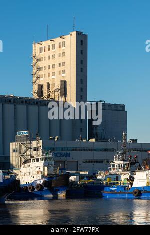 Remorqueurs dans le port de Québec avec élévateur de grain industriel en arrière-plan Banque D'Images