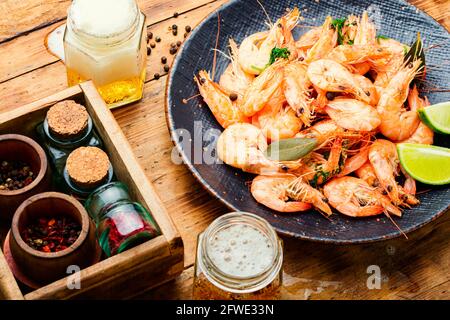 Grosses crevettes et bière bouillies en pots. Crevettes fraîches cuites arrière-plan en bois Banque D'Images