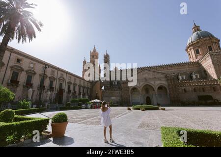 Femme prenant poto devant l'ancienne cathédrale de Palerme à la journée ensoleillée d'été. Banque D'Images