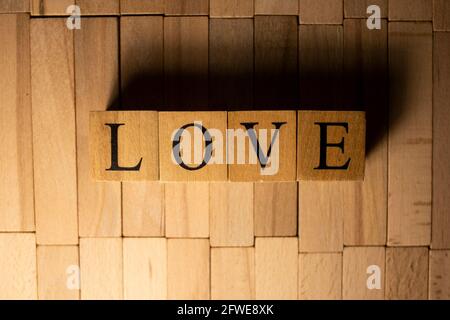 Le mot amour a été créé à partir de cubes en bois. La vie et l'homme. Gros plan.