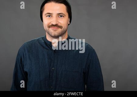 Happy hipster gars regarde l'appareil photo avec le sourire sur fond sombre, l'espace de copie Banque D'Images