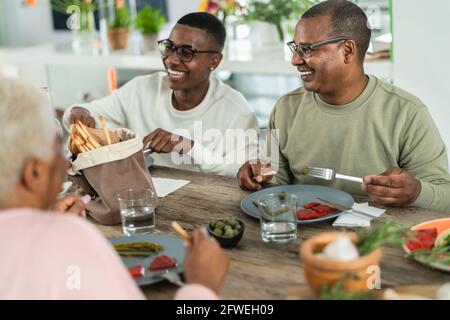 Bonne famille afro latine manger un déjeuner sain avec des légumes frais À la maison - concept de l'unité de la nourriture et des parents Banque D'Images