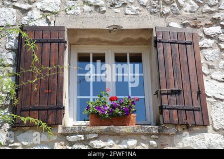 fenêtre avec volets bruns et fleurs colorées sur la fenêtre seuil Banque D'Images