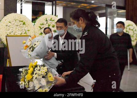 (210522) -- CHANGSHA, le 22 mai 2021 (Xinhua) -- les employés placent les fleurs présentées par les habitants de la région dans la salle commémorative de Yuan Longping au salon funéraire de Mingyangshan à Changsha, dans la province centrale de Hunan, le 22 mai 2021. Le corbillard transportant le corps de Yuan Longping a quitté l'hôpital Xiangya de l'Université Central South pour le salon funéraire à Changsha samedi. À mi-chemin, le cœur fit un détour au Hunan Hybrid Rice Research Center où Yuan a vécu et travaillé pendant longtemps. Le scientifique chinois Yuan Longping, renommé pour le développement de la première souche de riz hybride qui re Banque D'Images