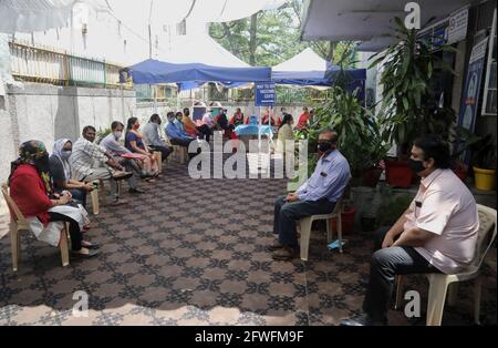 New Delhi, Inde. 22 mai 2021. Des personnes attendent d'être vaccinées avec le coronavirus COVAXIN (Covid-19) dans un dispensaire gouvernemental transformé en centre de vaccination.le gouvernement indien a approuvé le vaccin Covaxin mis au point par Bharat Biotech, plus de 1,458 millions de doses de vaccin Covid-19 ont été administrées en Inde le 21 mai. Avec cela, le nombre cumulé a atteint 193.3 millions selon le ministère de la Santé de l'Union. Le pays enregistre 257,299 nouveaux cas de coronavirus et 4,194 décès au cours des 24 dernières heures. Crédit : SOPA Images Limited/Alamy Live News Banque D'Images