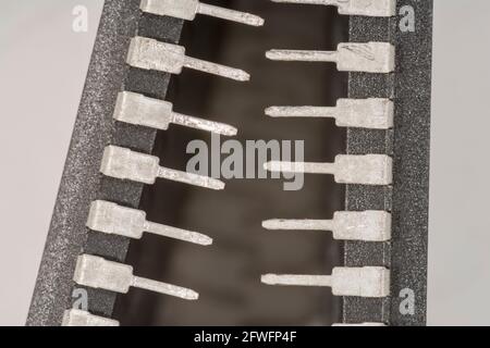 Macro gros plan des broches des pieds du semi-conducteur PIC16F77-I/P de Microchip Technology. Pour l'électronique résumé, composants industriels résumé. Banque D'Images