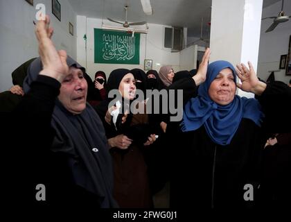 Gaza, Palestine. 21 mai 2021. Les femmes palestiniennes pleurent lors des funérailles des membres des brigades Ezz al-DIN al-Qassam (l'aile militaire de l'Organisation palestinienne du Hamas) qui ont été tués lors de bombardements israéliens d'un tunnel, lors de leurs funérailles dans la ville de Khan Younis, dans le sud de la bande de Gaza. Crédit : SOPA Images Limited/Alamy Live News Banque D'Images