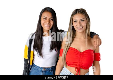 Portrait de deux jeunes femmes latines souriantes sur un fond blanc pur. Banque D'Images