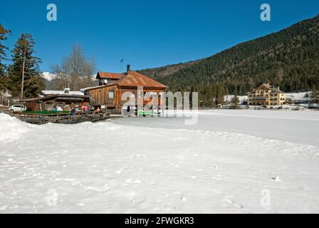 Lac Dobbiaco en hiver avec bar-restaurant sur pilotis et hôtel historique Baur (sur la droite), vallée de la Pusteria, Trentin-Haut-Adige, Italie Banque D'Images