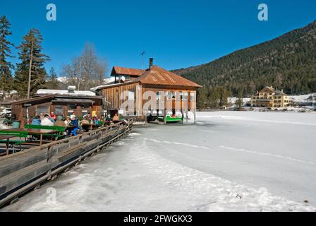 Lac Dobbiaco en hiver avec bar-restaurant sur pilotis et hôtel historique Baur (sur la droite), vallée de la Pusteria, Trentin-Haut-Adige, Italie Banque D'Images