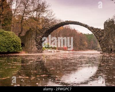 Feuilles colorées sur arbre à feuilles caduques au rond Rakotzbrucke également connu sous le nom de pont Devils à Azalea et Parc Rhododendron Kromlau, Allemagne. Banque D'Images