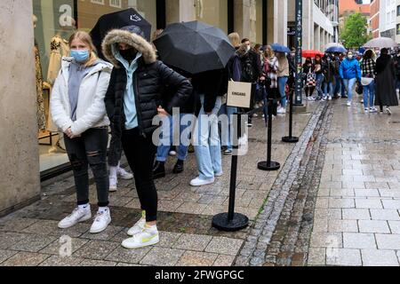 Münster, NRW, Allemagne. 22 mai 2021. De longues files d'attente se sont formées à l'extérieur d'un magasin Zara. La foule se rassemble dans le centre-ville historique de Münster, malgré les fortes pluies, car elle devient la première ville de Rhénanie-du-Nord-Westphalie à avoir le droit d'ouvrir des boissons et des repas à l'intérieur (avec test négatif ou vaccination), et des achats sans test ou rendez-vous (mais les chiffres sont limités). Münster a actuellement l'un des taux d'incidence de covid les plus bas en NRW à 17/100k et est devenu une « région de modèle » pour essayer la réouverture lente des lieux d'accueil. Credit: Imagetraceur/Alamy Live News Banque D'Images