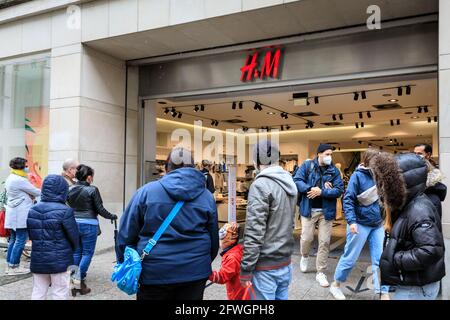 Münster, NRW, Allemagne. 22 mai 2021. De longues files d'attente se sont formées à l'extérieur d'un magasin « H&M ». La foule se rassemble dans le centre-ville historique de Münster, malgré les fortes pluies, car elle devient la première ville de Rhénanie-du-Nord-Westphalie à avoir le droit d'ouvrir des boissons et des repas à l'intérieur (avec test négatif ou vaccination), et des achats sans test ou rendez-vous (mais les chiffres sont limités). Münster a actuellement l'un des taux d'incidence de covid les plus bas en NRW à 17/100k et est devenu une « région de modèle » pour essayer la réouverture lente des lieux d'accueil. Credit: Imagetraceur/Alamy Live News Banque D'Images