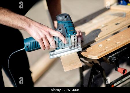 03 avril 2021, Basse-Saxe, Großenmeer: Hannes Wehrmann scie le bois devant sa Mercedes-Benz Sprinter, qu'il transforme en campervan avec sa petite amie Greta Thomas. Photo: Hauke-Christian Dittrich/dpa Banque D'Images