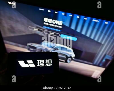 Personne tenant un smartphone avec le logo du fabricant chinois de voitures électriques Li Auto Inc à l'écran devant le site Web. Mise au point sur l'affichage du téléphone. Banque D'Images
