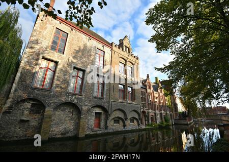 Bâtiments de style ancien gothique revival aux façades de briques sur les rives du canal de Groenerei dans le centre historique de Bruges en Belgique. Banque D'Images