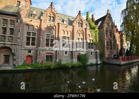 Bâtiments de style ancien gothique revival aux façades de briques sur les rives du canal de Groenerei dans le centre historique de Bruges en Belgique. Banque D'Images