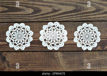 Napperons en dentelle crochet sur fond de bois Banque D'Images