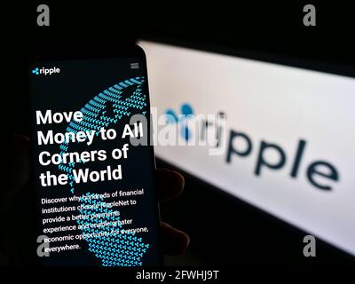 Personne tenant un téléphone mobile avec la page Web de la société américaine de technologie Ripple Labs Inc à l'écran devant le logo. Concentrez-vous sur le centre de l'écran du téléphone. Banque D'Images