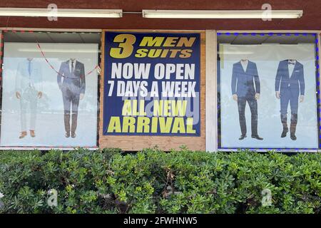 Une affiche « maintenant ouvert 7 jours PAR semaine » sur 3 hommes costumes, samedi 22 mai 2021, à Montebello, Calif. Banque D'Images