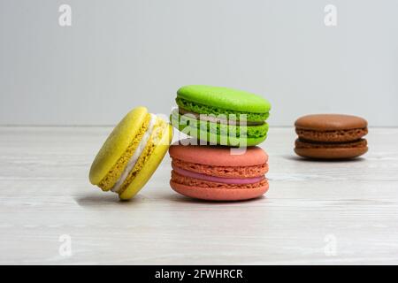 Quatre macarons multicolores sur une table de cuisine lumineuse Banque D'Images