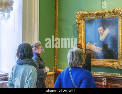 Guide de visite féminin portant un masque facial de sécurité devant la peinture à un groupe de visiteurs, Musée de l'Hermitage, Russie Banque D'Images