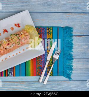 Péruvien traditionnel plat appelé causa faite de purée de piment (AJI) et le jus de lime et remplie de légumes (maïs, pois, carottes) et Banque D'Images