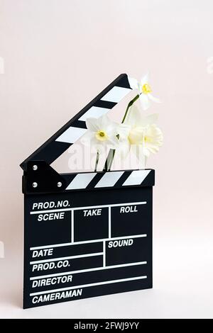 Tableau de bord d'un film avec fleurs printanières. Durée de vie minimale de la planche clapper pour faire du cinéma vidéo et des fleurs de jonquilles. Banque D'Images