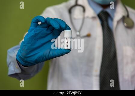 Flacon de vaccin d'échantillon Covid 19 tenu à la main de un médecin Banque D'Images