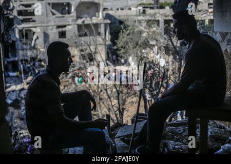 Les Palestiniens s'assoient parmi les décombres de leurs maisons détruites après le cessez-le-feu entre Israël et les militants de Gaza dans la ville de Beit Hanoun, dans le nord de la bande de Gaza. Après 11 jours de combats, le cessez-le-feu est entré en vigueur entre Israël et les militants de la bande de Gaza, sous la supervision d'une initiative égyptienne visant à mettre fin à un incendie inconditionnel. Selon le Ministère palestinien de la santé, au moins 232 Palestiniens ont été tués lors de l'attaque israélienne, tandis qu'au moins 12 Israélites ont été tués lors d'attaques à la roquette en provenance de Gaza. (Photo de Mahmoud Issa/SOPA Images/Sipa USA) Banque D'Images