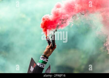 Main d'un manifestant lors de la manifestation nationale pour la Palestine, la Palestine libre, à Londres, Royaume-Uni, laissant des éruptions rouges et vertes, leurs couleurs nationales Banque D'Images