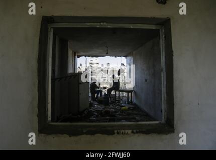 Les Palestiniens s'assoient parmi les décombres de leurs maisons détruites après le cessez-le-feu entre Israël et les militants de Gaza dans la ville de Beit Hanoun, dans le nord de la bande de Gaza. Après 11 jours de combats, le cessez-le-feu est entré en vigueur entre Israël et les militants de la bande de Gaza, sous la supervision d'une initiative égyptienne visant à mettre fin à un incendie inconditionnel. Selon le Ministère palestinien de la santé, au moins 232 Palestiniens ont été tués lors de l'attaque israélienne, tandis qu'au moins 12 Israélites ont été tués lors d'attaques à la roquette en provenance de Gaza. Banque D'Images