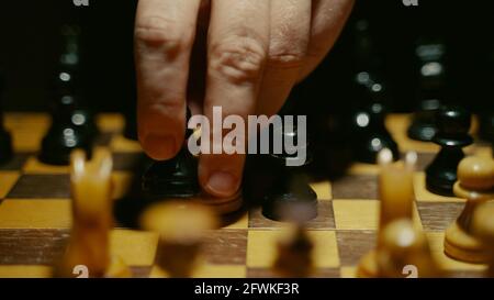 La personne utilise le pion sur le plateau dans le jeu d'échecs.