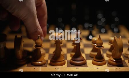 La personne utilise le pion sur le plateau dans le jeu d'échecs.