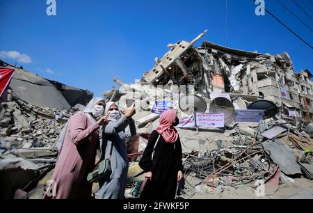 Gaza, Palestine. 23 mai 2021. Les femmes palestiniennes posent pour un selfie devant un bâtiment démoli dans le quartier commercial d'Al-Remal à Gaza, récemment visé par des frappes aériennes israéliennes.les Gazaouis ont commencé à pider leur vie après un conflit dévastateur avec Israël qui a tué plus de 200 personnes et fait des milliers de sans-abri dans le Enclave palestinienne appauvrie, quelques jours après un cessez-le-feu négocié par l'Égypte, qui a mis fin à des frappes aériennes israéliennes mortelles et à des tirs de roquettes en direction d'Israël. (Photo par Ahmed Zakot/SOPA Images/Sipa USA) crédit: SIPA USA/Alay Live News Banque D'Images