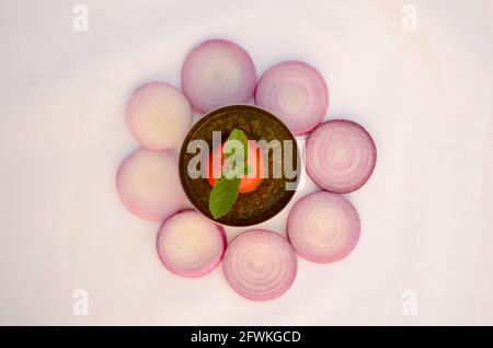 oignon tranché avec tomate, sauce à la menthe et menthe verte isolé sur fond blanc. Banque D'Images