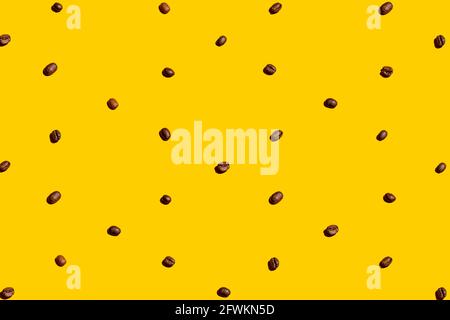 Grains de café organisés et formant une texture sur fond jaune. Banque D'Images